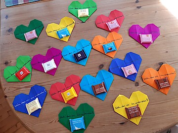 Mehrere der oben beschriebenen Herzen in verschiedenen Farben auf einem Holztisch.